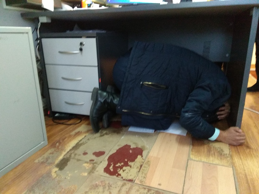 Picture of Bank's employees taking cover under desks