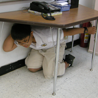 Picture of boy in the 'Drop, Cover, and Hold On' position